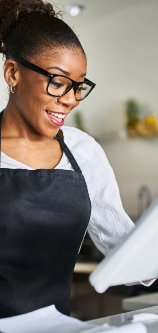 Cashier using a modern point-of-sale system with integrated payment processing solutions.