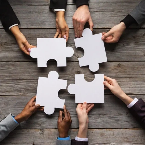 Hands fitting puzzle pieces together, symbolizing seamless payment processing solutions.
